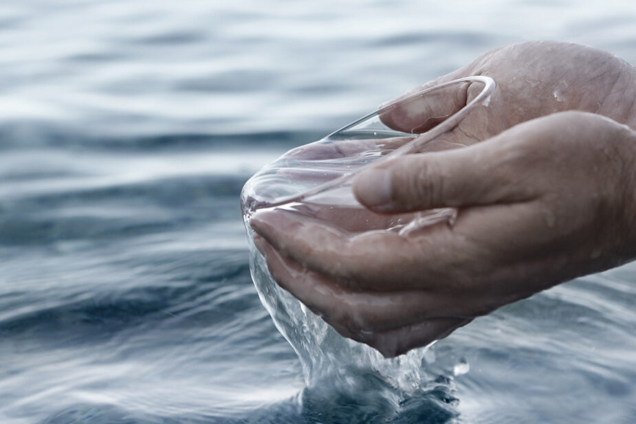 Hands scooping water from the ocean.